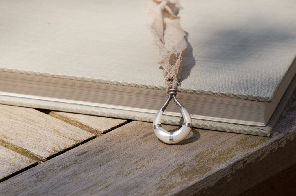 A horseshoe shaped silver and and mother of pearl inlay pendant